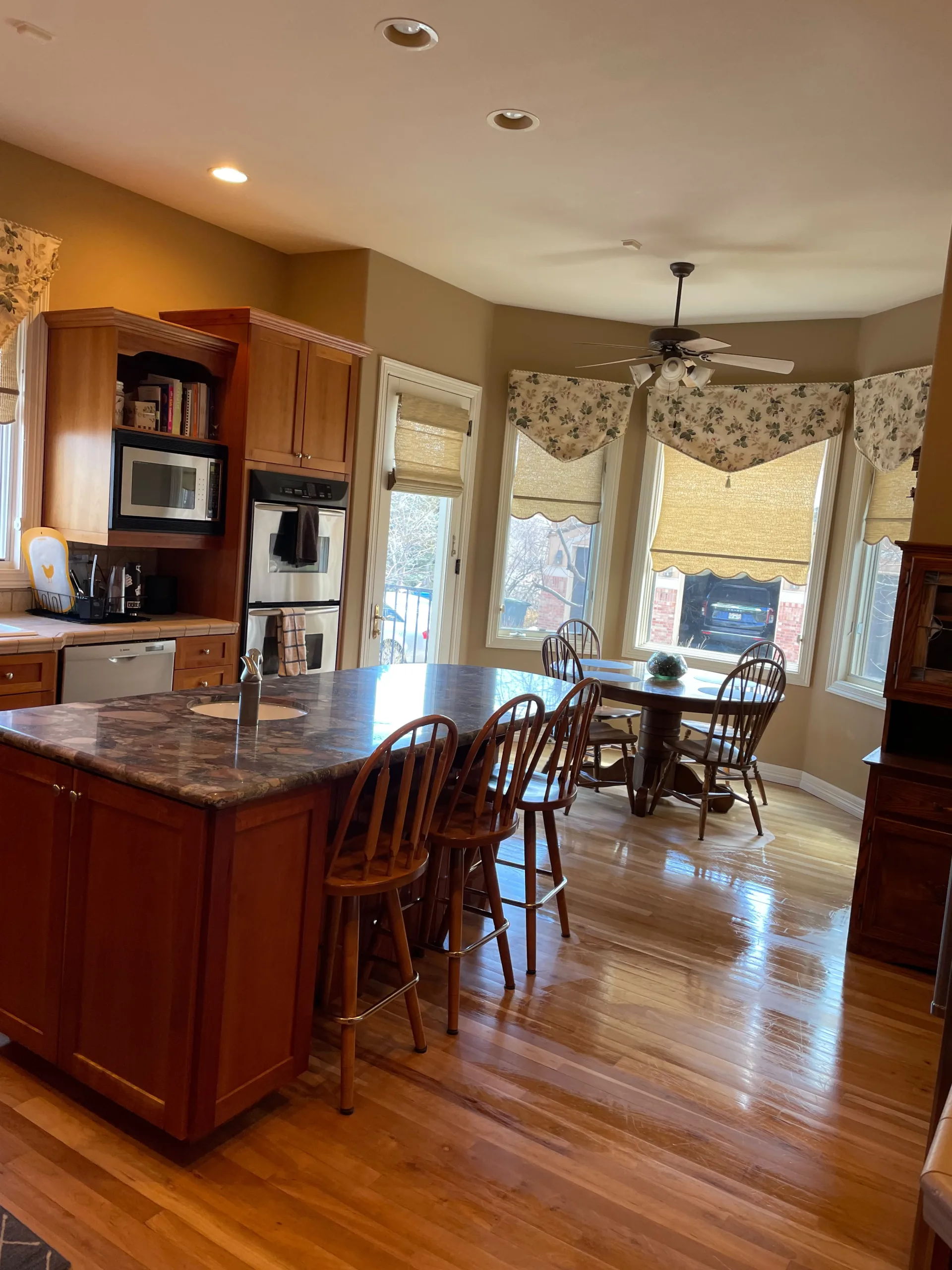 Traditional kitchen and breakfast nook with polished hardwood floors, cleaned by the Romero Cleaning team